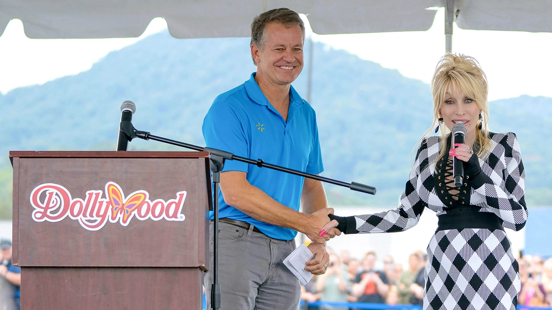Dolly Parton shakes hands with Walmart President and CEO John Furner at Walmart Store #678 in Newport, Tenn.