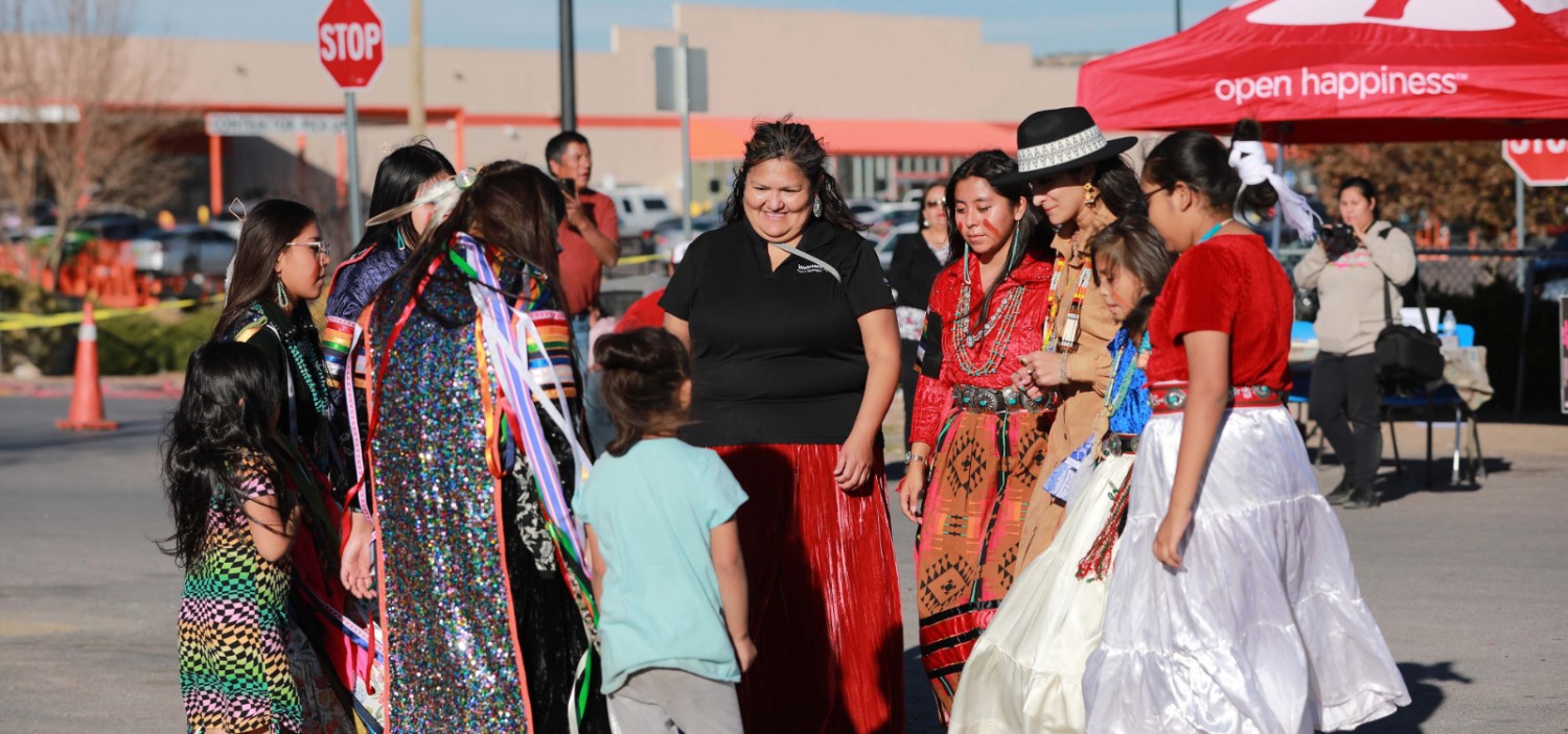 Marcie at a Native American Heritage Month festival surrounded by a group of people
