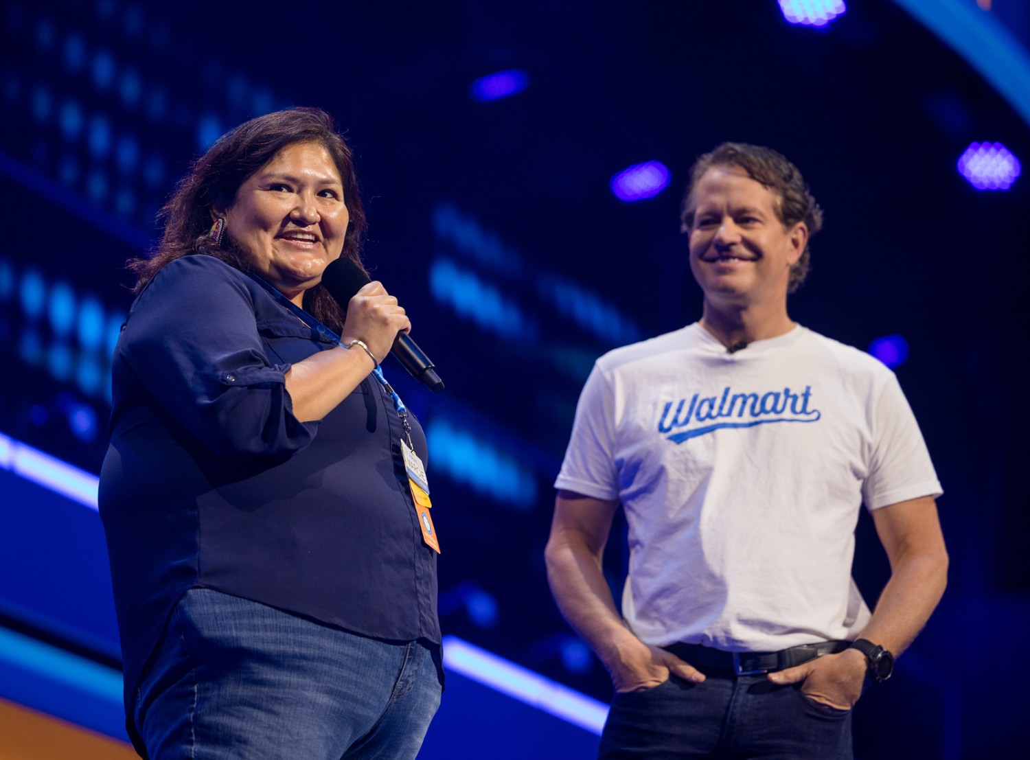 Marcie on a stage with John Furner during Shareholders meeting